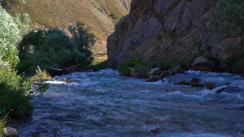 Dersim'in dağlık coğrafyasında kayalar arasında köpürerek akan güçlü nehir görüntüsü. Doğanın enerjisini yansıtan yüksek kaliteli stok video.
