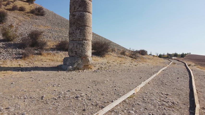Drone perspektifiyle çekilen bu görüntü, Karakuş Tümülüsü'nün tarihi sütununu, çevresindeki kırsal arazi ve antik atmosfer ile birlikte etkileyici bir kompozisyon halinde sunmaktadır.