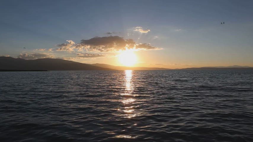 Ardahan Kura Nehri'nde gün batımını ve güneşin suya yansımasını gösteren doğal stok videosu.