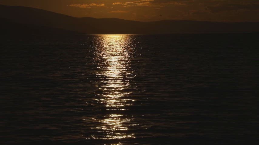 Ardahan Kura Nehri'nde altın saatte çekilmiş gün batımı ve su yansımasını gösteren doğal stok videosu.