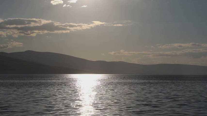 Ardahan Kura Nehri üzerinde gün batımını ve su yüzeyindeki doğal yansımaları gösteren stok video.
