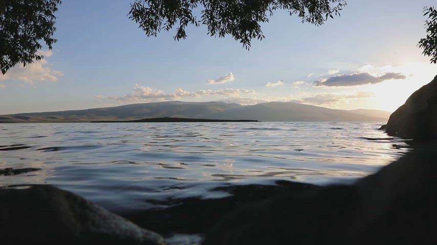 Ardahan Kura Nehri'nde su seviyesinden çekilmiş gün batımı manzarasını gösteren stok video.