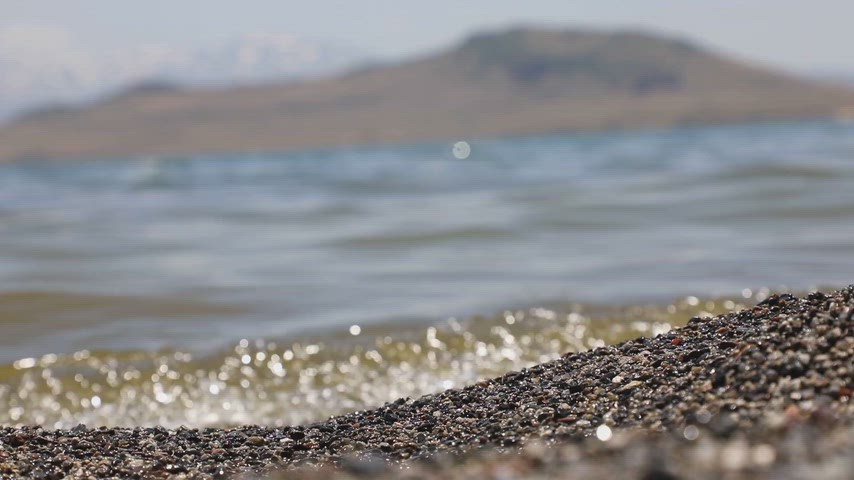 Bitlis Tatvan sahilinde kum taneleri ve Van Gölü'nün hafif dalgalarını gösteren yüksek kaliteli stok video.