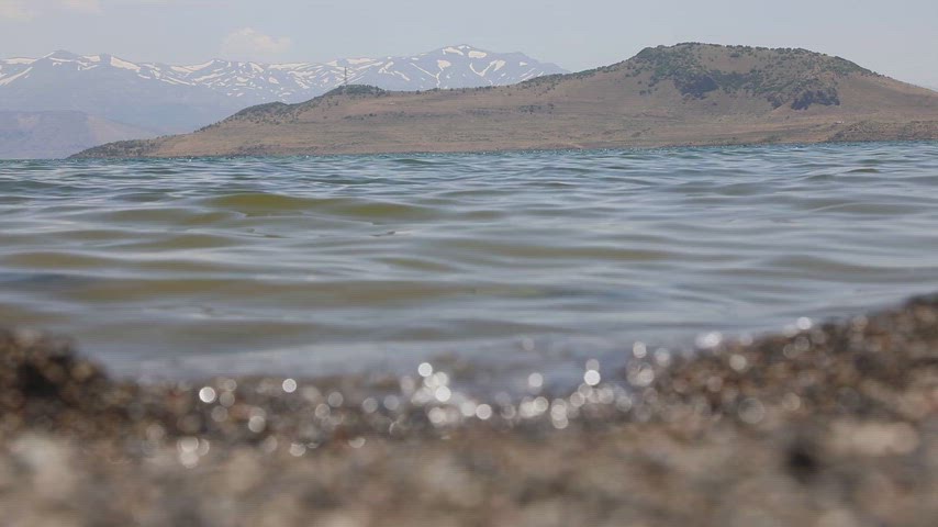 Tatvan sahilinde Van Gölü dalgalarının kıyıya ulaştığı doğal manzarayı gösteren profesyonel stok video.