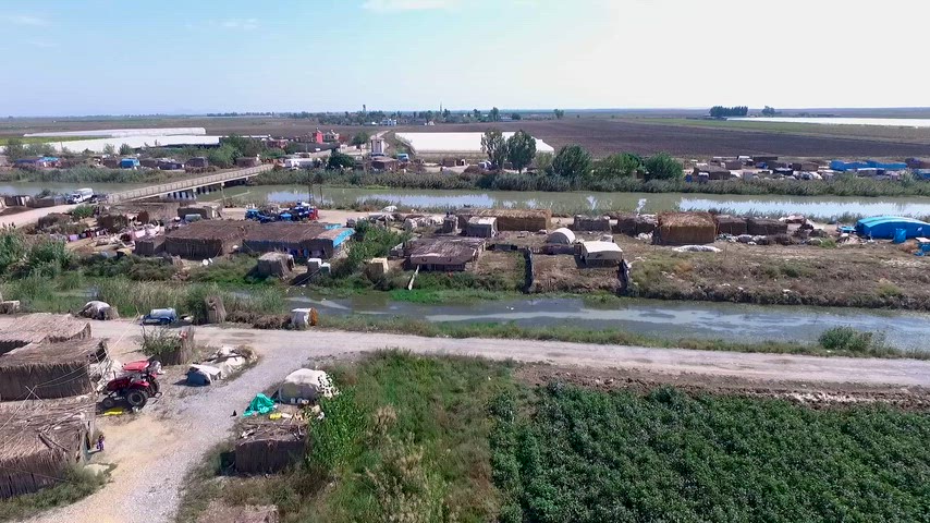 Adana Çadırkent'te kanal, köprü, seralar ve tarım arazilerinin havadan drone görüntüsü.