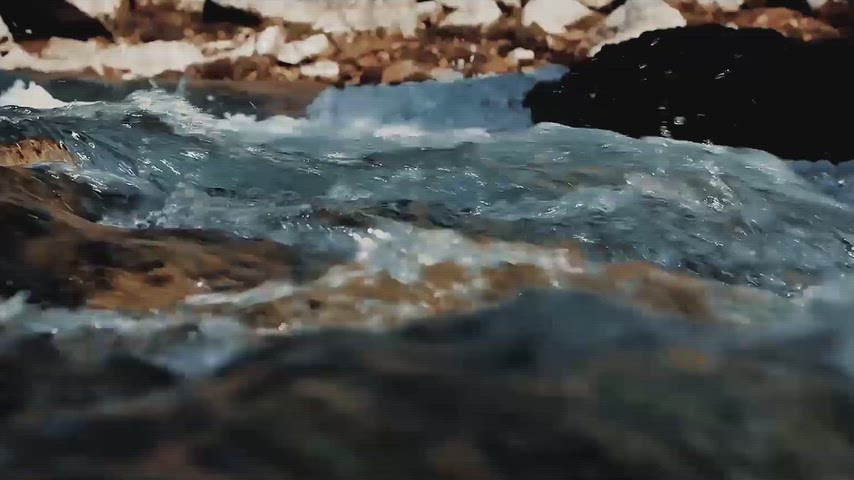 Dersim Munzur Çayı'nda kayalar üzerinden akan berrak su ve güçlü akıntının yakın plan doğal görüntüsü.