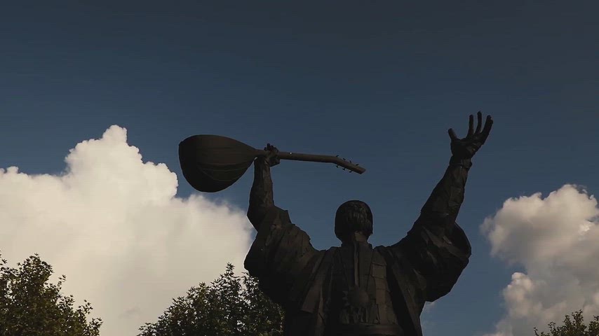 Dersim Tunceli'deki Pir Sultan Abdal Heykeli'nin bağlama ile gökyüzüne karşı silüetini gösteren kültürel görüntü.