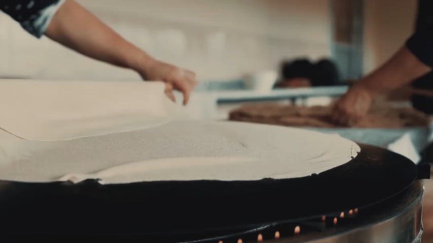 Sac üzerinde geleneksel yufka ekmeği yapımını ve el emeğini gösteren yüksek çözünürlüklü yakın plan görüntü.