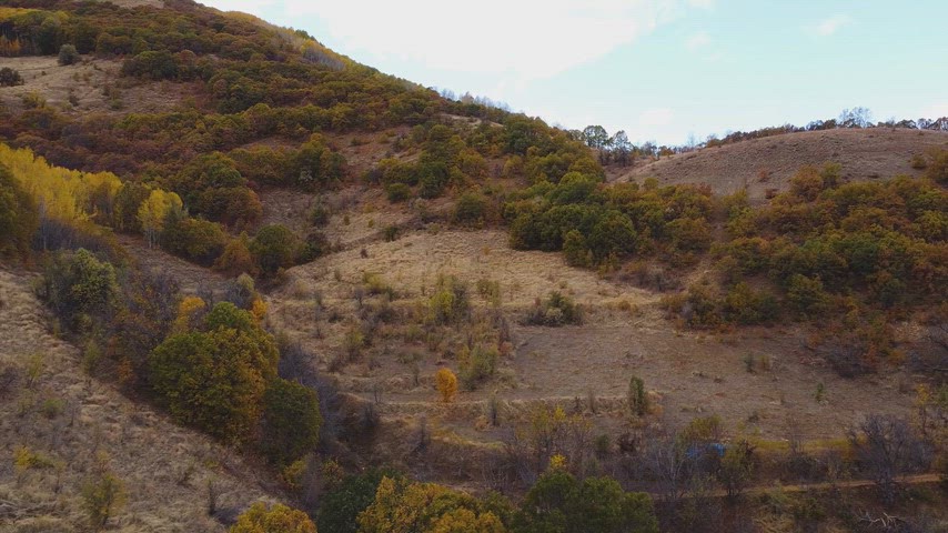 Dersim Pülümür vadisindeki sonbahar yamaçları ve dağ eteklerini gösteren yüksek çözünürlüklü drone hava çekimi.