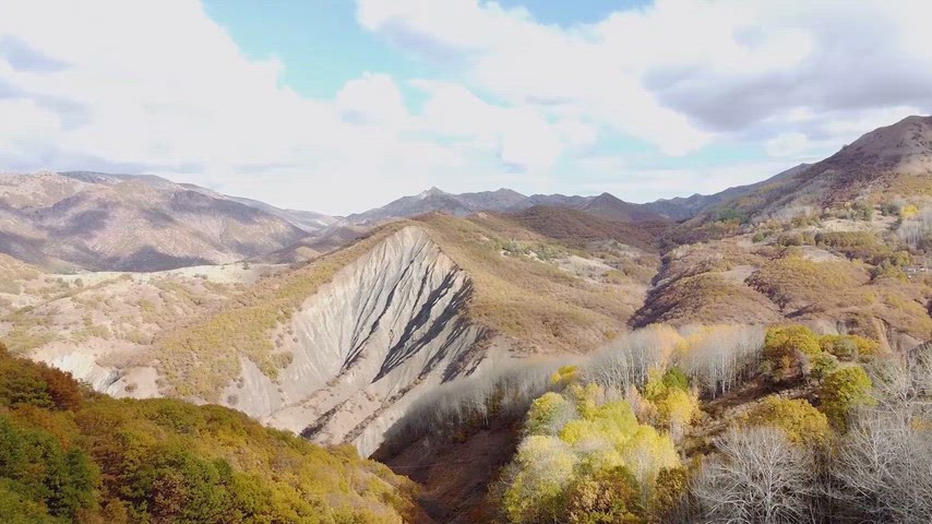 Drone ile çekilen sonbahar dağ ve vadi manzarası, doğal renk geçişleriyle etkileyici panoramik doğa görüntüsü sunuyor.