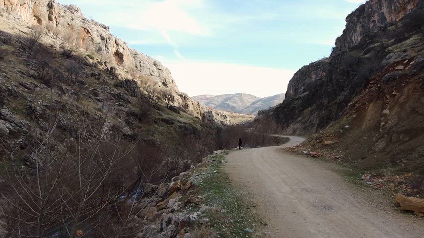 Çermik Sinek Çayı vadisinde kayalık yol, dere yatağı ve doğal manzara.