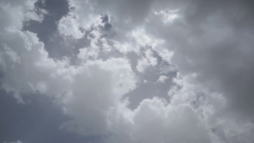 Hızlı hareket eden bulutlar ve güneş ışıklarıyla oluşan dramatik time-lapse gökyüzü görünümü.