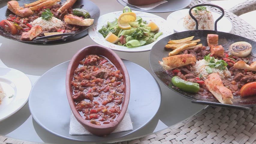 Malabadi Köprüsü üzerinde sunulan çömlek güveç, pilav ve salata çeşitlerini gösteren tarihi atmosferde geleneksel yemek video