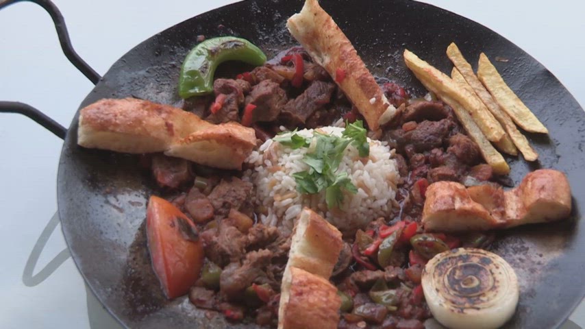 Tavada servis edilen et sote, pilav, patates kızartması ve garnitürlerle hazırlanan sıcak yemek sunumu