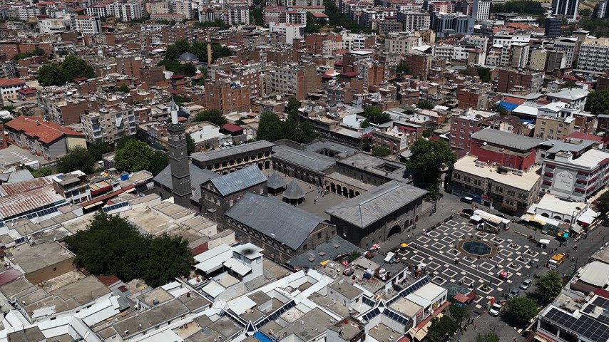 6K drone ile çekilen Diyarbakır Ulu Camii ve tarihi Sur ilçesinin panoramik hava görüntüsü. Anadolu'nun en önemli İslam eserlerinden biri olan Ulu Camii, bazalt taş mimarisi ve geniş avlusuyla dikkat çeker. Tarihi sokaklar, geleneksel şehir dokusu ve kent meydanı aynı karede yer almaktadır.