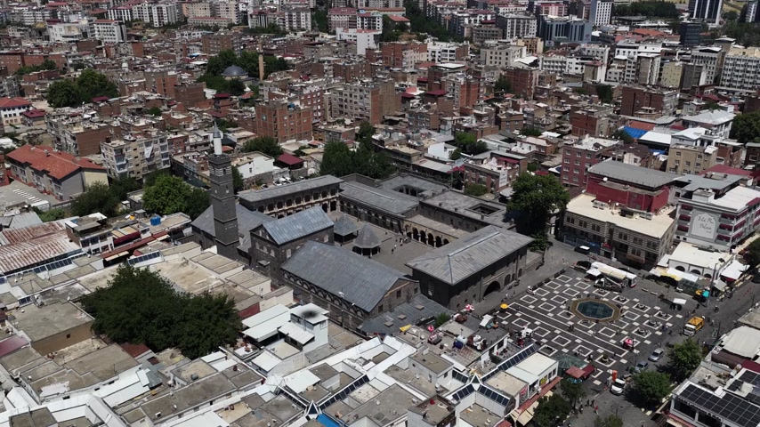 Diyarbakır şehir merkezindeki Ulu Camii ve çevresindeki tarihi Sur içi yerleşiminin havadan drone ile çekilmiş panoramik görüntüsü. Cami avlusu, minare, tarihi taş yapılar, dar sokak dokusu ve yoğun kent yerleşimi doğal ışıkta görüntülenmiştir. Diyarbakır’ın kültürel mirası, tarihi mimarisi, şehir dokusu ve turizm tanıtımları için uygun yüksek çözünürlüklü stok videodur.