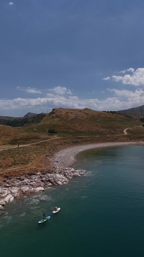 Van Gölü kıyısında paddle board yapan iki sporcuyu ve berrak göl manzarasını gösteren etkileyici hava çekimi.