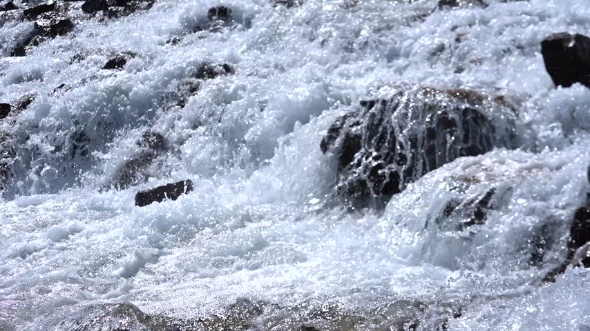 Dersim Ovacık'ta kayalık dere yatağından akan köpüklü ve berrak dağ suyunun doğal manzara videosu