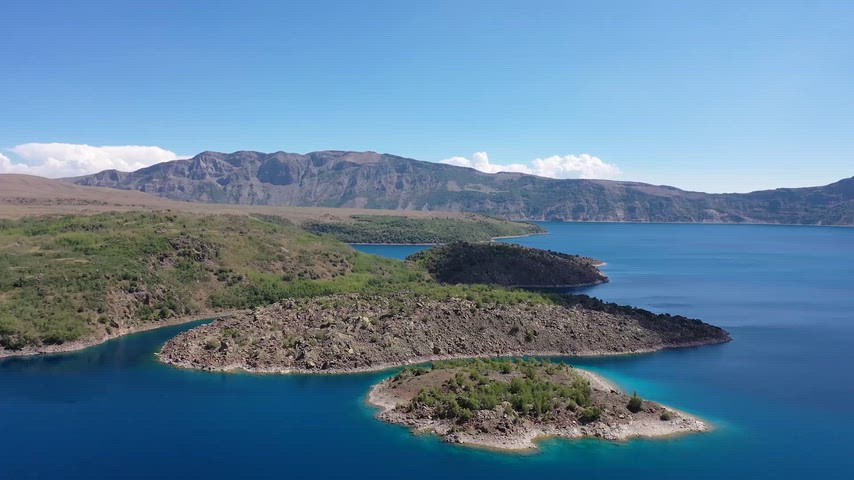 Bu yüksek çözünürlüklü drone videosu, berrak mavi sulara sahip sakin bir göl ve çevresindeki yeşil adaları havadan gösteriyor